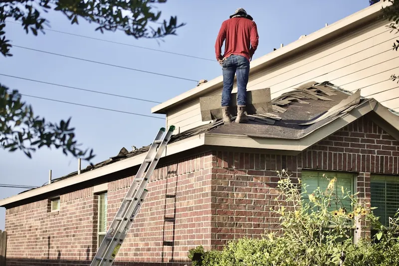 Professional roofer working on a residential roof in Roots